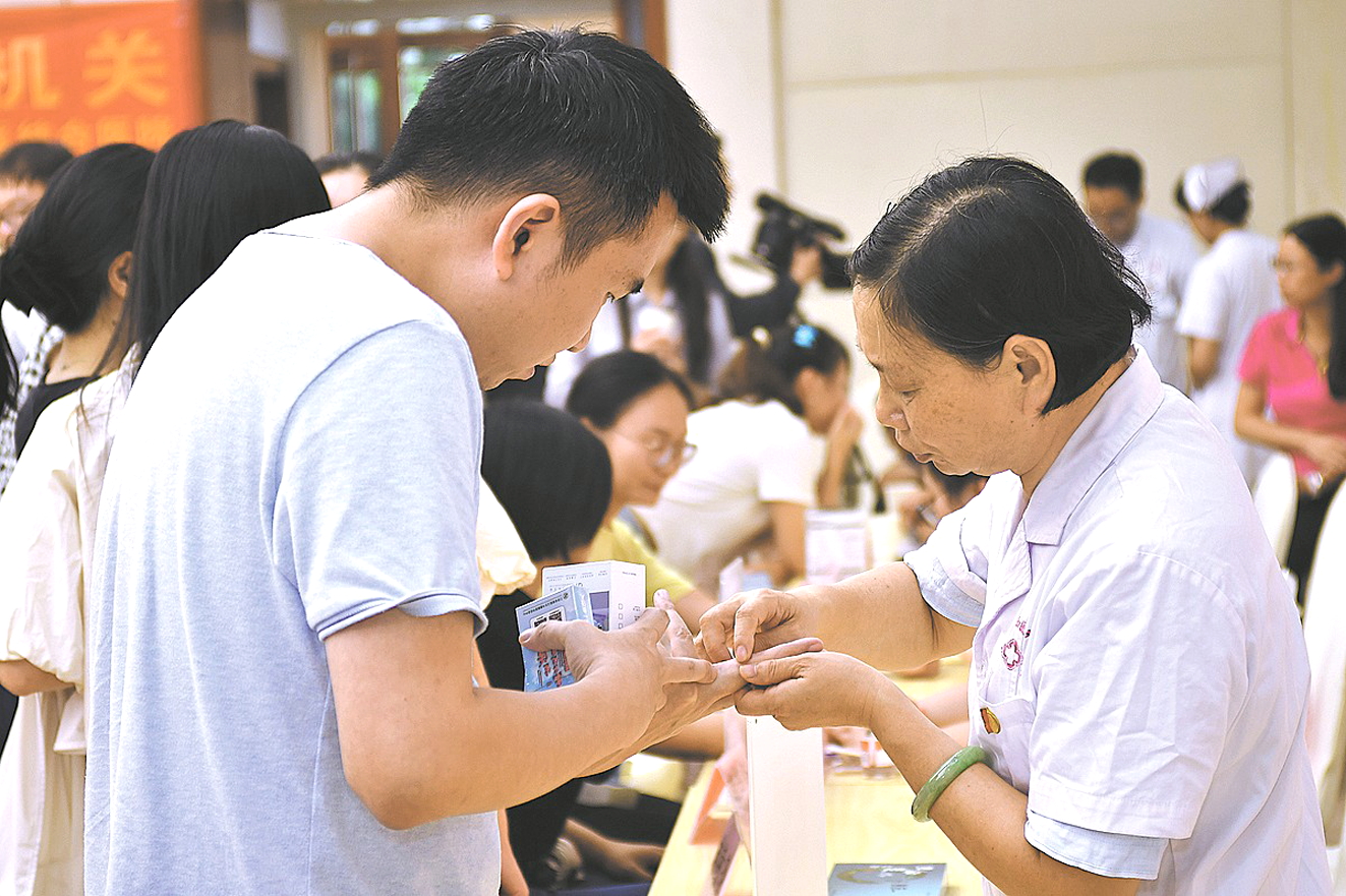Nh&acirc;n vi&ecirc;n y tế kiểm tra sức khỏe cho một bệnh nh&acirc;n trẻ tại sự kiện ch&acirc;m cứu ở th&agrave;nh phố Nam Xương, tỉnh Giang T&acirc;y, Trung Quốc, ng&agrave;y 8/8/2024 - Nguồn ảnh: China Daily