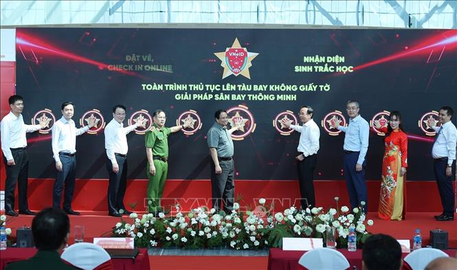 Thủ tướng Phạm Minh Ch&iacute;nh v&agrave; c&aacute;c đại biểu bấm n&uacute;t triển khai giải ph&aacute;p ứng dụng định danh, x&aacute;c thực điện tử, v&agrave; nhận diện sinh trắc học phục vụ l&ecirc;n t&agrave;u bay. Ảnh: Dương Giang - TTXVN