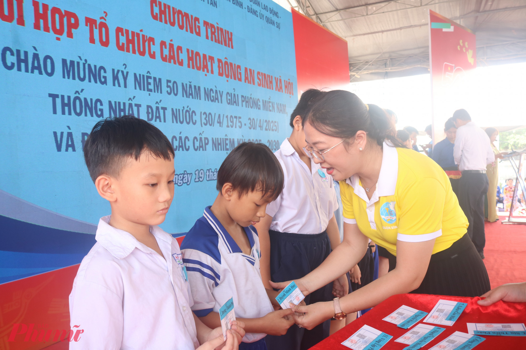 B&agrave; Huỳnh Đặng H&agrave; Tuy&ecirc;n &ndash; Chủ tịch Hội LHPN quận B&igrave;nh T&acirc;n &ndash; trao thẻ bảo hiểm y tế cho c&aacute;c em học sinh.