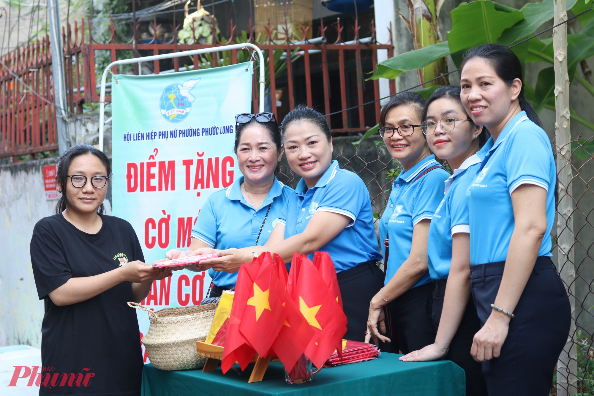 Người d&acirc;n hẻm 51, đường 359, khu phố 18, phường Phước Long B nhận những l&aacute; cờ Tổ quốc mới để trao trước cửa nh&agrave;. 