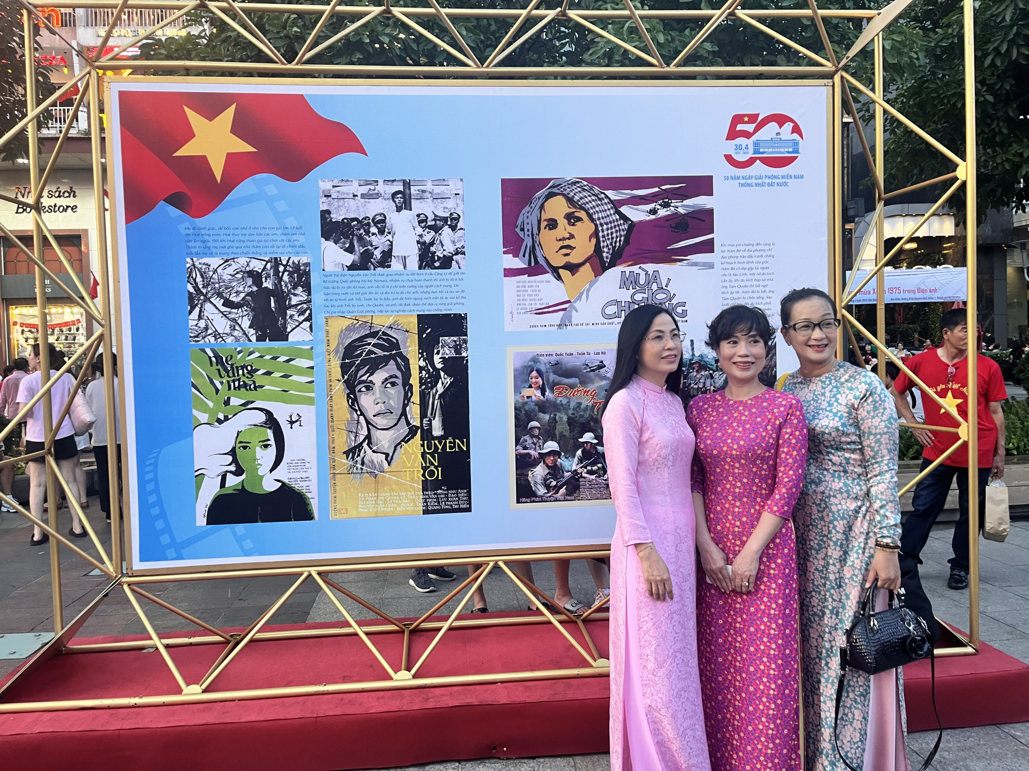 Nhiều người d&acirc;n diện &aacute;o d&agrave;i chụp h&igrave;nh lưu niệm trước những tấm poster phim