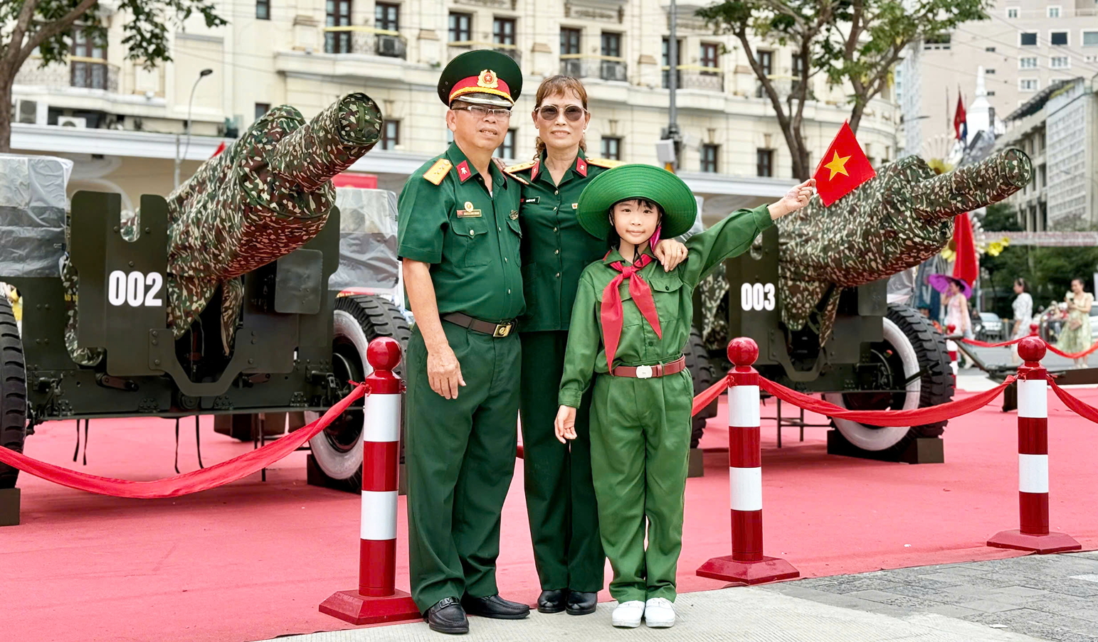 B&eacute; Nguyễn Lưu Gia An chụp h&igrave;nh lưu niệm với c&aacute;c &ocirc;ng b&agrave; cựu chiến binh  b&ecirc;n c&aacute;c khẩu ph&aacute;o được trưng b&agrave;y trang trọng ở bến Bạch Đằng - ẢNH: CH&Iacute; THIỆN