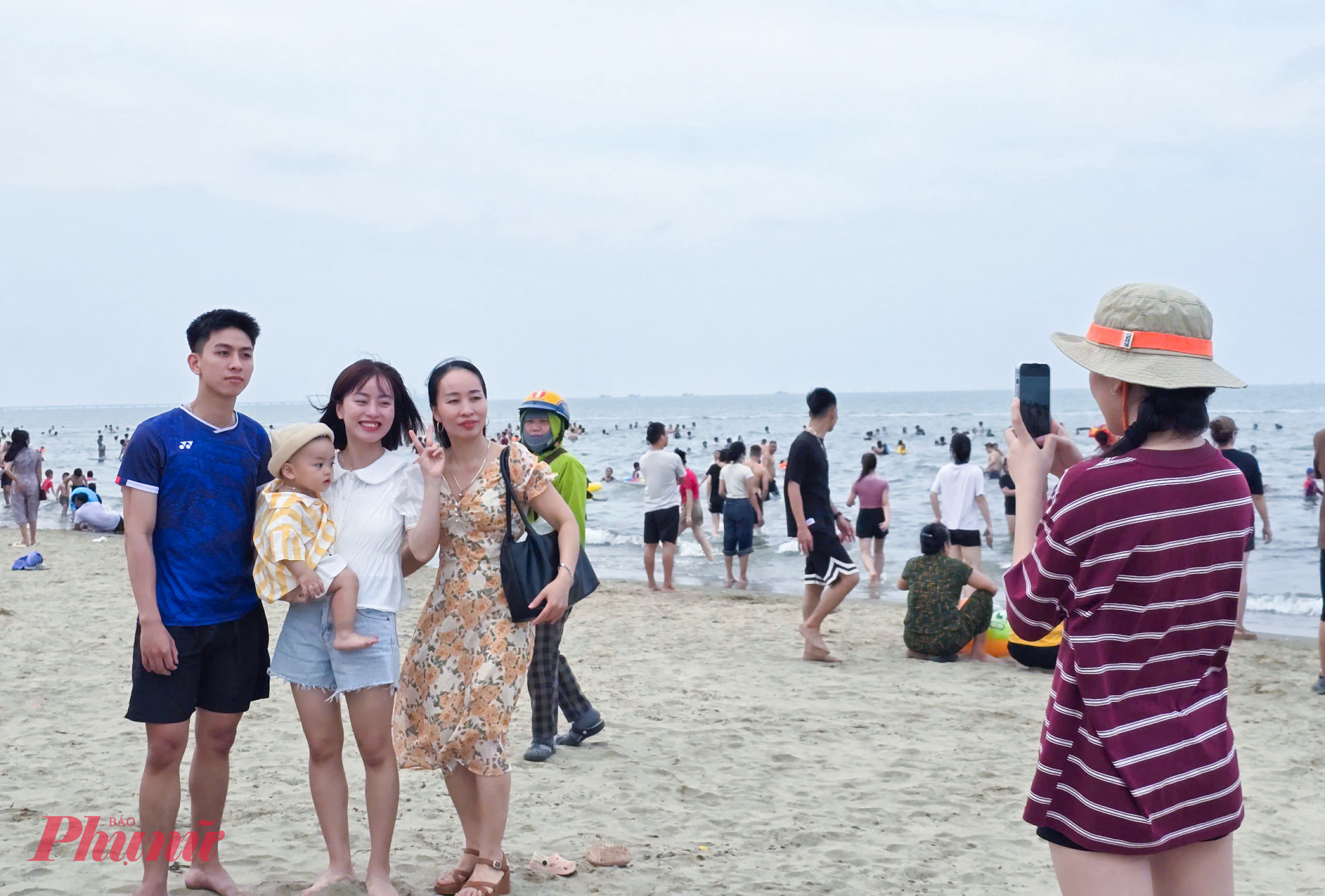 Một gia đ&igrave;nh lưu lại tấm ảnh kỷ niệm b&ecirc;n b&atilde;i biển Cửa L&ograve;.
