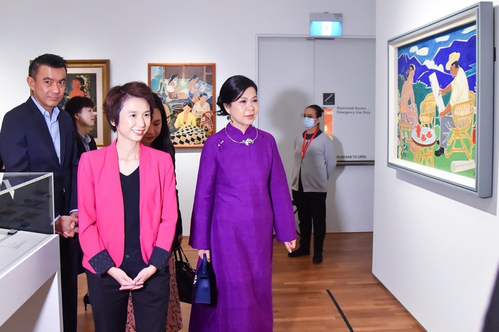 Cũng tại Singapore, Phu nh&acirc;n Ng&ocirc; Phương Ly rạng rỡ trong bộ &aacute;o d&agrave;i m&agrave;u t&iacute;m s&aacute;nh bước c&ugrave;ng với Quốc vụ khanh Singapore Low Yen Ling đ&atilde; đến thăm Bảo t&agrave;ng tranh quốc gia Singapore - Ảnh: TTXVN