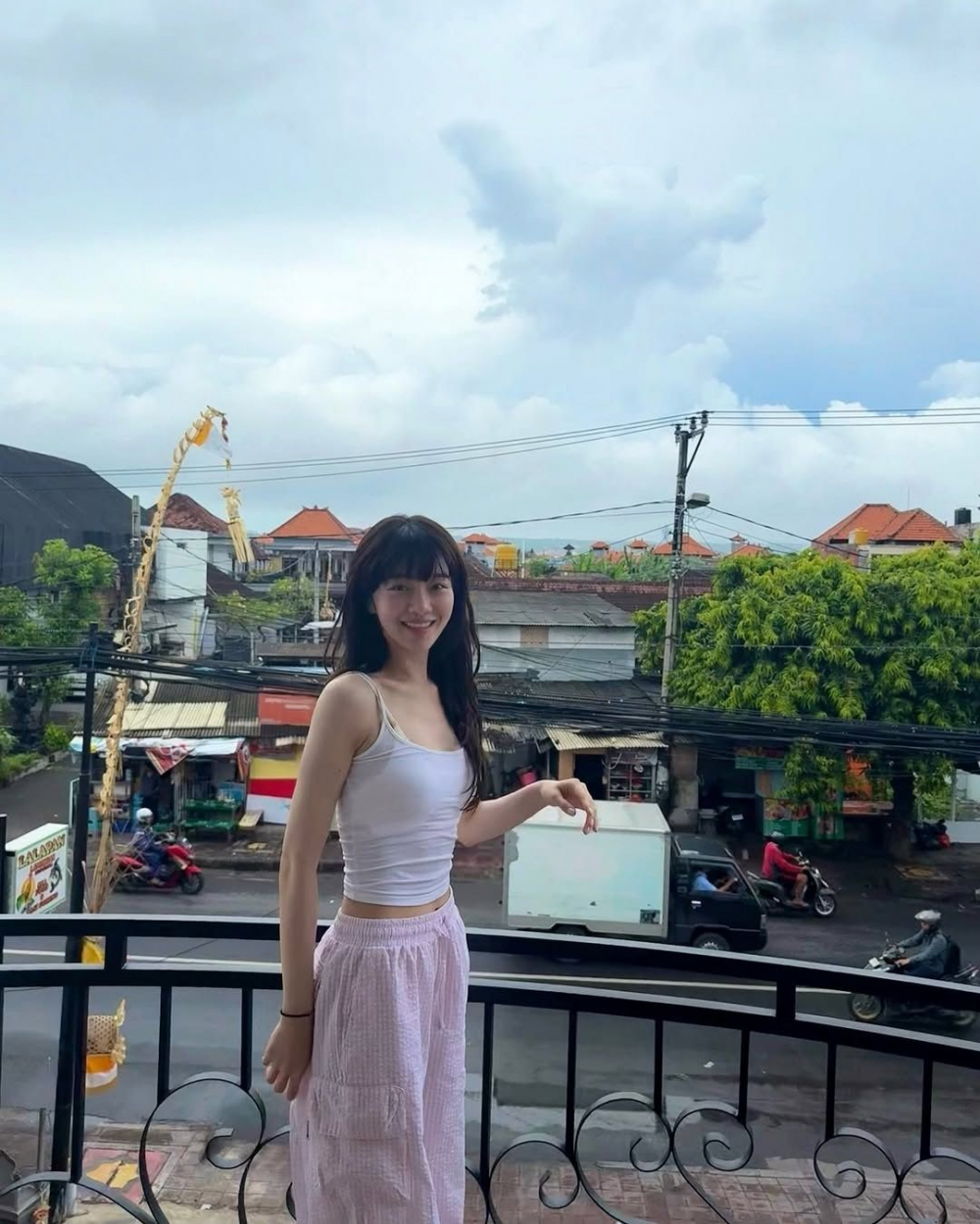 Park Gyu Young lại mang đến một c&aacute;ch tiếp cận mềm mại hơn: c&ocirc; layer camisole nude c&ugrave;ng &aacute;o thun trắng &ocirc;m s&aacute;t b&ecirc;n trong, kết hợp với quần seersucker s&aacute;ng m&agrave;u. Kiểu phối đồ n&agrave;y tạo cảm gi&aacute;c m&aacute;t mẻ, nhẹ nh&agrave;ng m&agrave; vẫn gi&uacute;p t&ocirc;n d&aacute;ng, rất ph&ugrave; hợp cho những ng&agrave;y nắng oi bức.