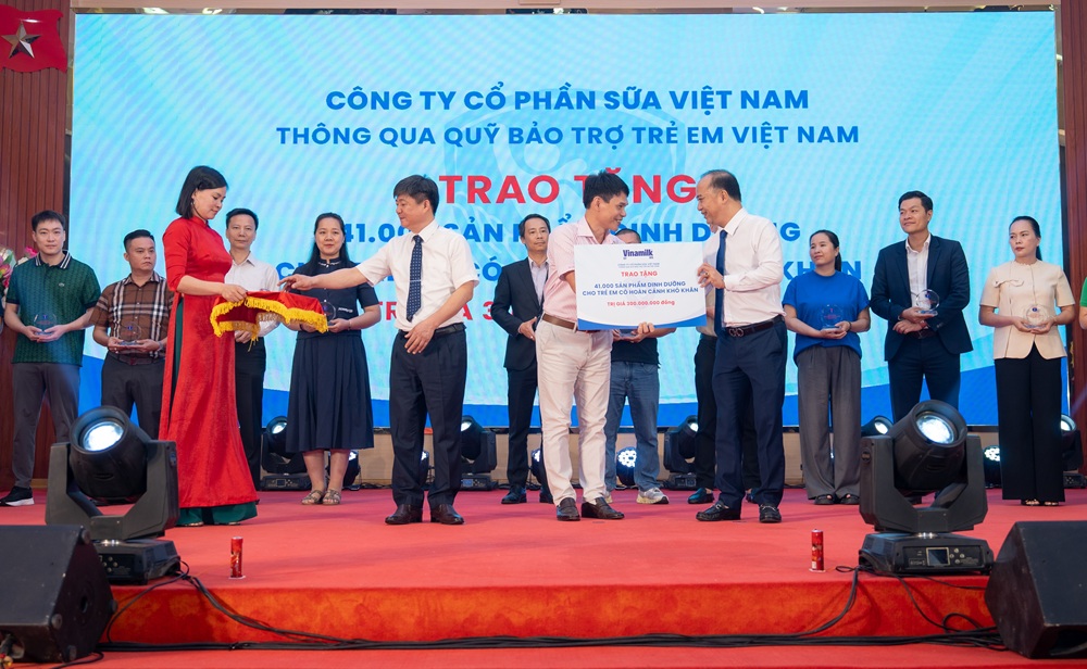 &Ocirc;ng Phạm Tuy&ecirc;n - Gi&aacute;m đốc chi nh&aacute;nh Vinamilk H&agrave; Nội (đứng giữa) trao bảng tượng trưng m&oacute;n qu&agrave; 41.000 hộp sữa cho trẻ em Ph&uacute; Thọ - Ảnh: Minh H&agrave;