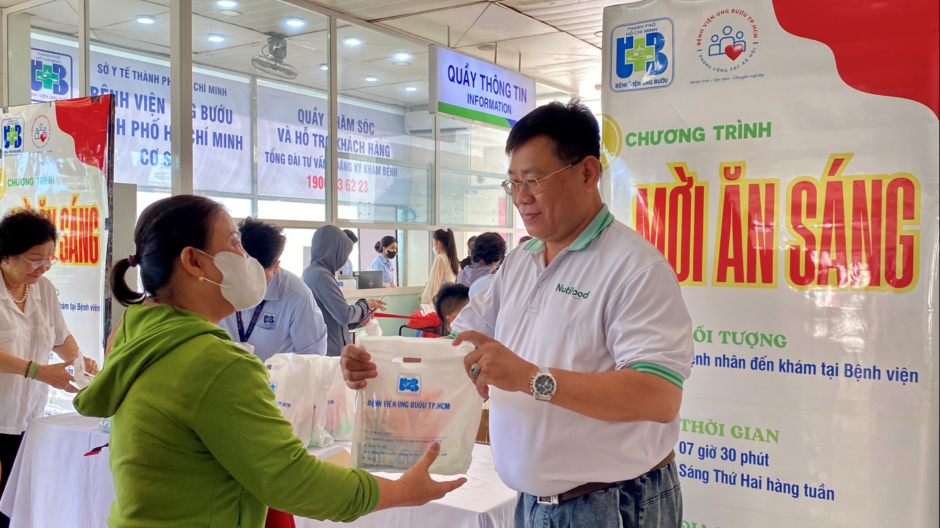 Đại diện Nutifood trao phần ăn s&aacute;ng cho b&agrave; con - Ảnh: Nutifood