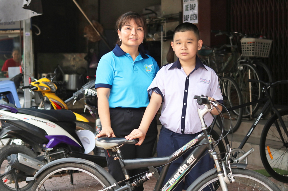 Chị Nguyễn Thị Hồng Thu mua xe đạp mới cho ch&aacute;u Trần Minh Ph&uacute;c - ẢNH: MẪN NHI