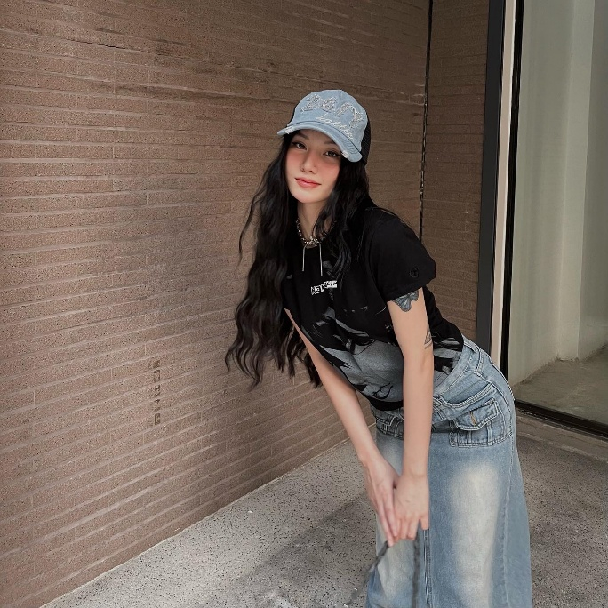 Khi đi dạo phố, em xinh Saabirose chọn &aacute;o thun đen in h&igrave;nh kết hợp c&ugrave;ng ch&acirc;n v&aacute;y denim d&agrave;i, tạo cảm gi&aacute;c tinh nghịch v&agrave; năng động. Chi tiết loang m&agrave;u tr&ecirc;n nền vải gi&uacute;p trang phục tr&ocirc;ng mềm hơn v&agrave; bớt đơn điệu. C&ocirc; đội mũ lưỡi trai denim s&aacute;ng m&agrave;u c&oacute; th&ecirc;u chữ để th&ecirc;m phần trẻ trung. Kh&ocirc;ng thể qu&ecirc;n th&ecirc;m thắt ch&uacute;t gai g&oacute;c qua v&ograve;ng cổ dạng d&acirc;y x&iacute;ch để tăng sự nổi bật m&agrave; kh&ocirc;ng l&agrave;m rối mắt.