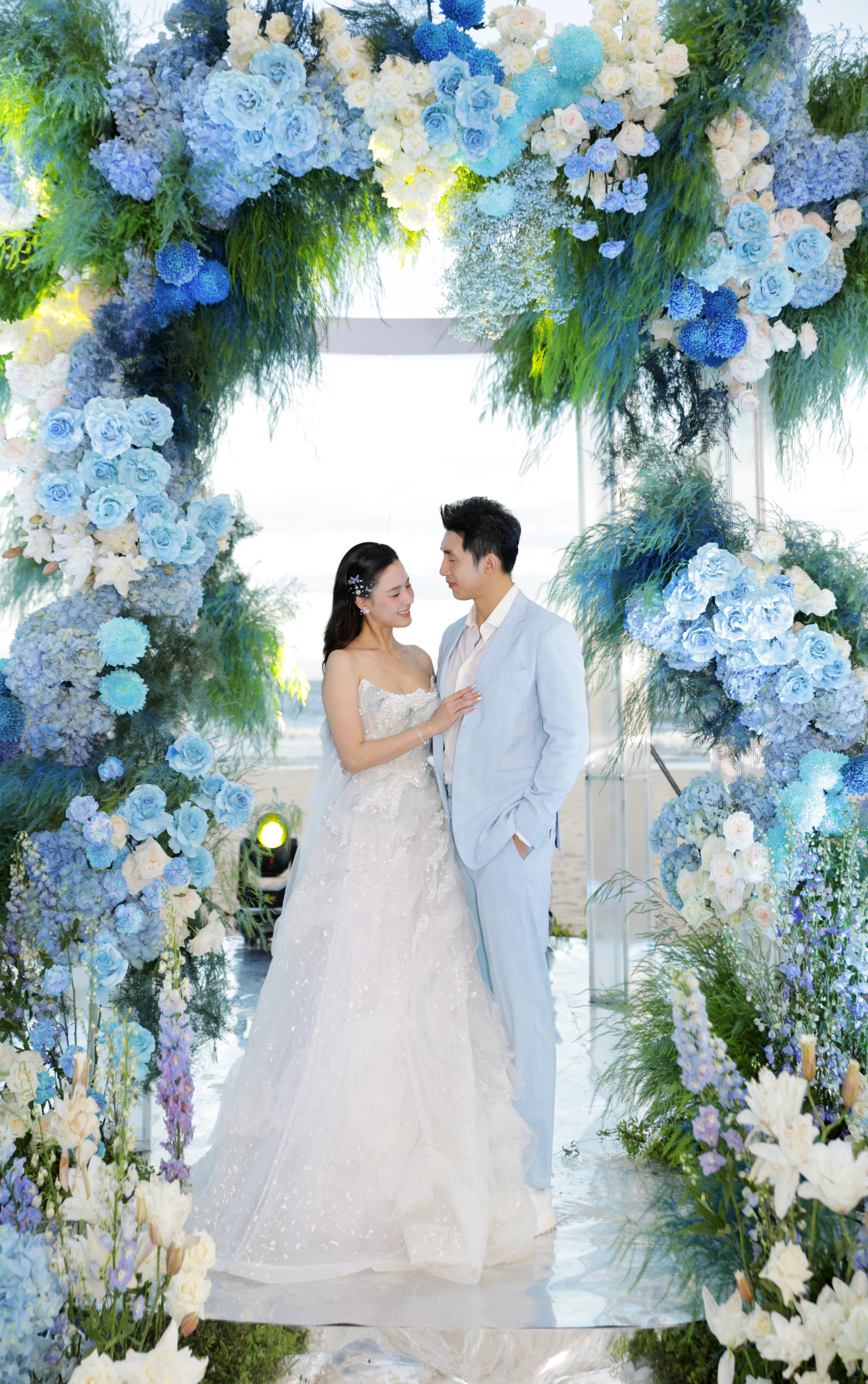  S&aacute;nh đ&ocirc;i c&ugrave;ng vợ, doanh nh&acirc;n Minh Đạt diện vest t&ocirc;ng xanh dương đồng điệu, tạo n&ecirc;n h&igrave;nh ảnh cặp đ&ocirc;i &ldquo;trai t&agrave;i g&aacute;i sắc&rdquo; nhận được nhiều lời khen từ cư d&acirc;n mạng.
