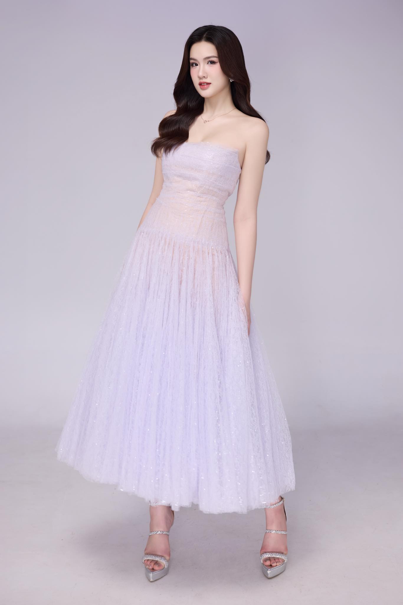 &Aacute; hậu Trịnh Mỹ Anh ghi điểm với vẻ đẹp thanh tho&aacute;t trong chiếc đầm pastel &aacute;nh t&iacute;m nhạt. Thiết kế c&uacute;p ngực, chất liệu voan lấp l&aacute;nh c&ugrave;ng phần v&aacute;y x&ograve;e nhẹ gi&uacute;p t&ocirc;n d&aacute;ng v&agrave; tăng n&eacute;t nữ t&iacute;nh, sang trọng.