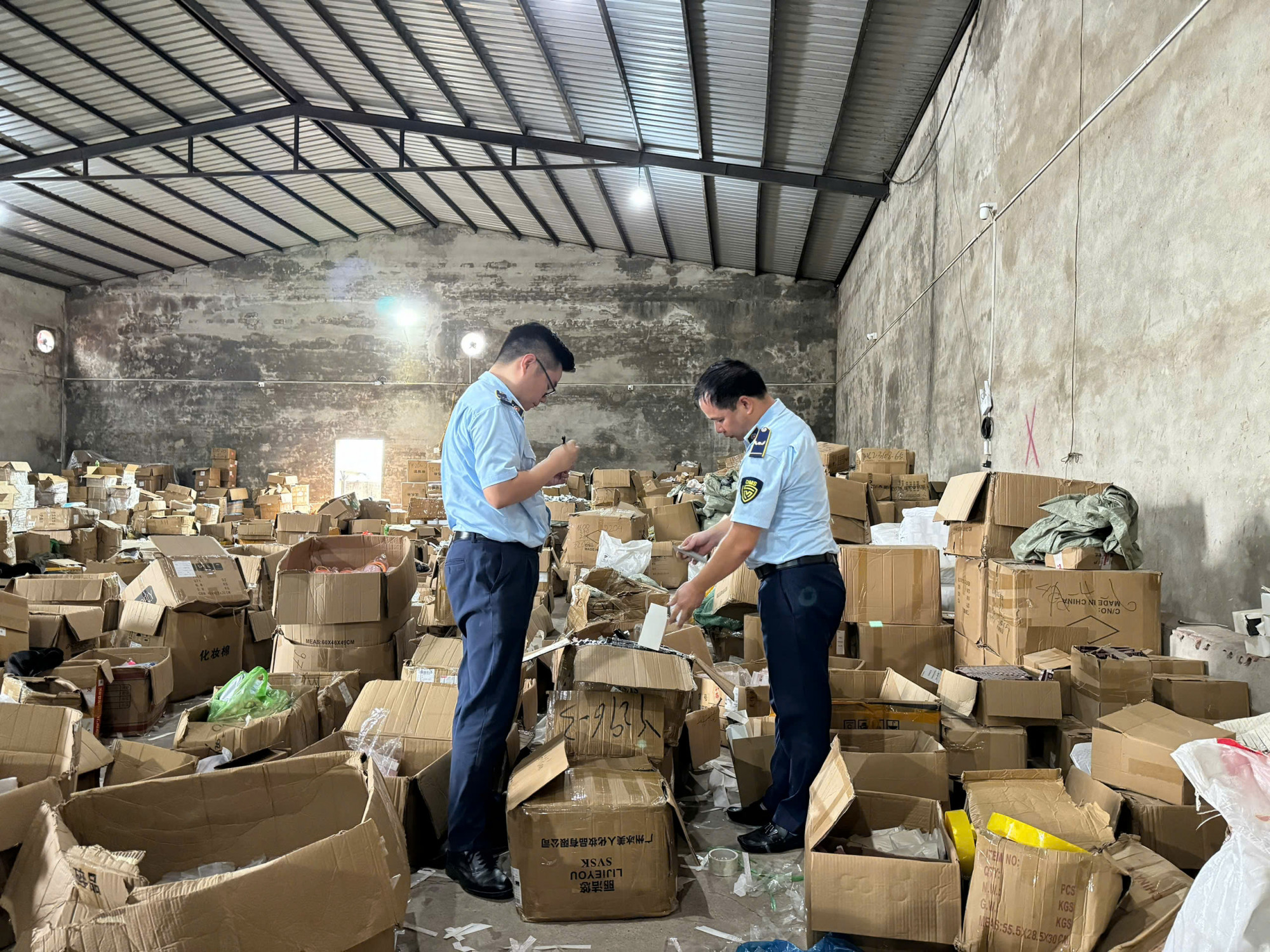 Lực lượng chức năng kiểm đếm h&agrave;ng h&oacute;a bị thu giữ - Ảnh: Cục Quản l&yacute; v&agrave; Ph&aacute;t triển thị trường trong nước