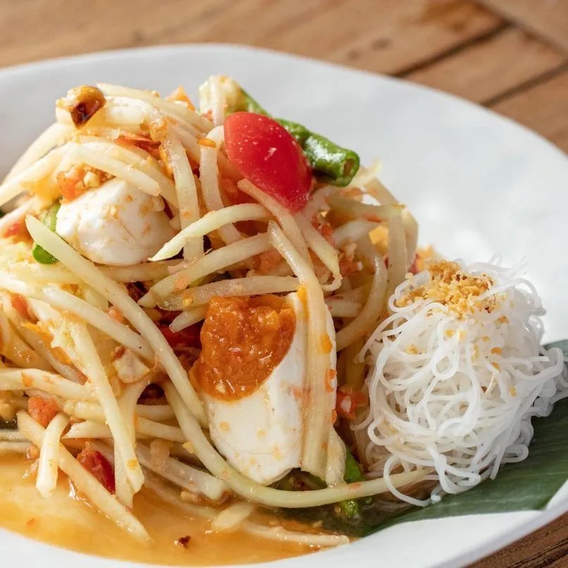 Baan Somtum. Som tuam ở đ&acirc;y rất đa dạng, gồm: đu đủ, dưa leo, đậu que c&ugrave;ng cua, h&agrave;u, x&uacute;c x&iacute;ch. C&aacute;c m&oacute;n nổi bật l&agrave;: som tum c&agrave; rốt kiểu Th&aacute;i, som tum dừa, đu đủ chi&ecirc;n gi&ograve;n sốt som tum rất hấp dẫn. Baan Somtum c&oacute; nhiều chi nh&aacute;nh ở Bangkok - Ảnh: Baan Somtum