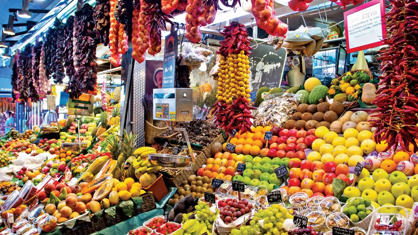 Mercat De La Boqueria ở Barcelona, T&acirc;y Ban Nha. Thường được gọi l&agrave; La Boqueria, chợ c&oacute; hơn 200 quầy h&agrave;ng b&aacute;n c&aacute;c loại thịt x&ocirc;ng kh&oacute;i, ph&ocirc; mai, ớt chu&ocirc;ng, dầu olives, b&aacute;nh tortilla, rượu sangria, h&agrave;ng thủ c&ocirc;ng mỹ nghệ.. Nằm tr&ecirc;n phố La Rambla ở Barcelona, chợ c&oacute; từ những năm 1800 v&agrave; l&agrave; một trong những khu chợ l&acirc;u đời nhất của T&acirc;y Ban Nha.