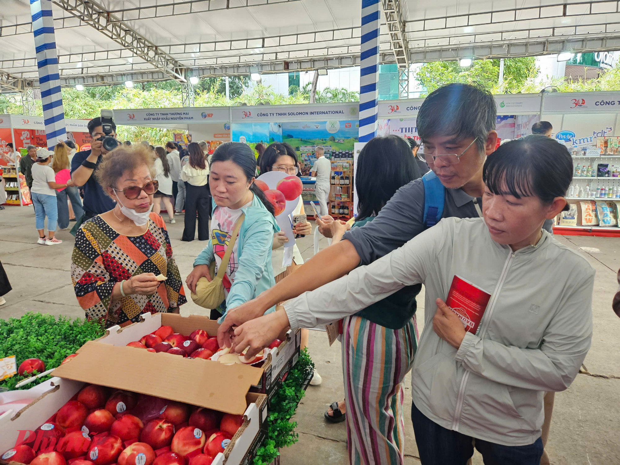 T&aacute;o Mỹ &ndash; một trong những loại tr&aacute;i c&acirc;y nhập khẩu được người Việt ưa chuộng &ndash; được trưng b&agrave;y trong th&ugrave;ng lớn, c&oacute; tem truy xuất nguồn gốc r&otilde; r&agrave;ng. Nhiều kh&aacute;ch tham quan dừng lại thử vị v&agrave; đ&aacute;nh gi&aacute; chất lượng sản phẩm.