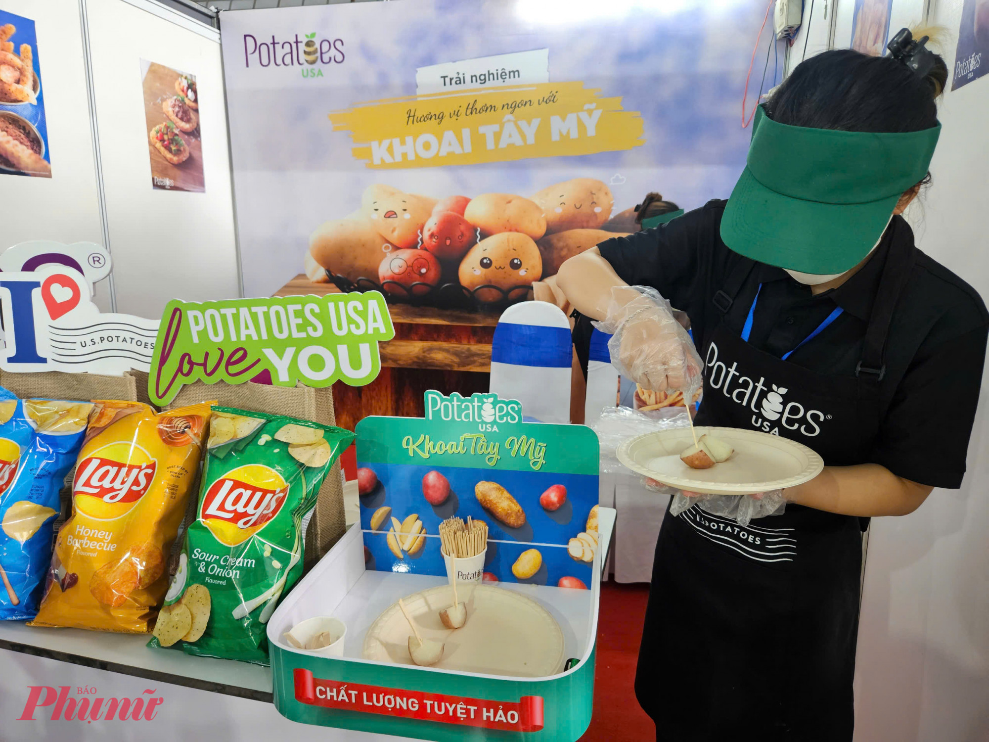Nh&acirc;n vi&ecirc;n Potatoes USA chuẩn bị phần khoai t&acirc;y hấp cắt l&aacute;t d&ugrave;ng thử cho kh&aacute;ch tham quan. Ngo&agrave;i sản phẩm khoai tươi, c&aacute;c d&ograve;ng khoai chế biến sẵn như chips Lay&rsquo;s cũng được trưng b&agrave;y.