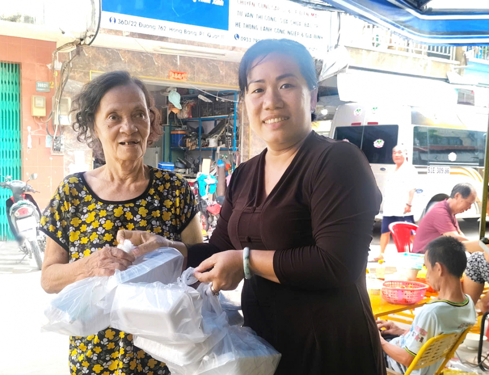 B&agrave; Nguyễn Thị Thanh Nguyệt (phường Minh Phụng) trao c&aacute;c suất ăn miễn ph&iacute; cho người kh&oacute; khăn