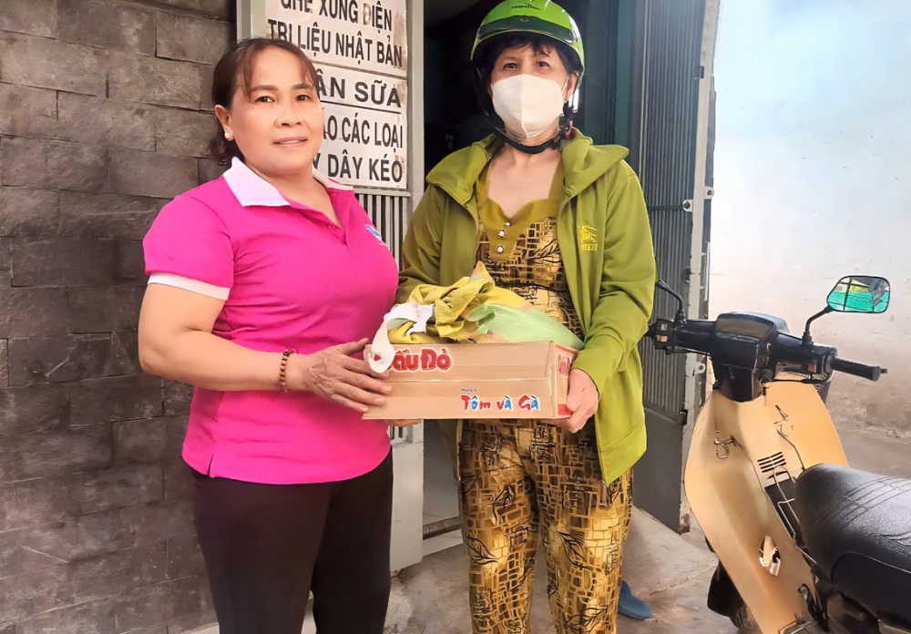 B&agrave; V&otilde; Thị Nhanh - Chi hội trưởng Chi hội Phụ nữ khu phố 26, phường T&acirc;n Ph&uacute; - tặng bữa ăn v&agrave; c&aacute;c nhu yếu phẩm đến người kh&oacute; khăn