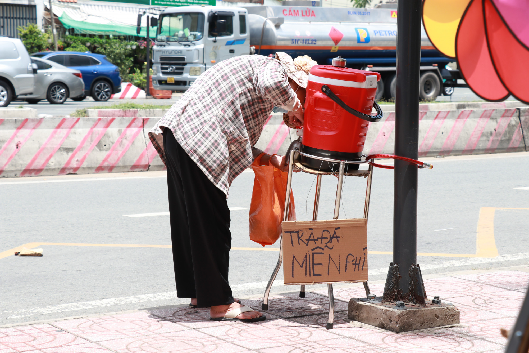 Người d&acirc;n đến lấy tr&agrave; đ&aacute; miễn ph&iacute; được qu&aacute;n đặt tại trạm xe bus tr&ecirc;n vỉa h&egrave;