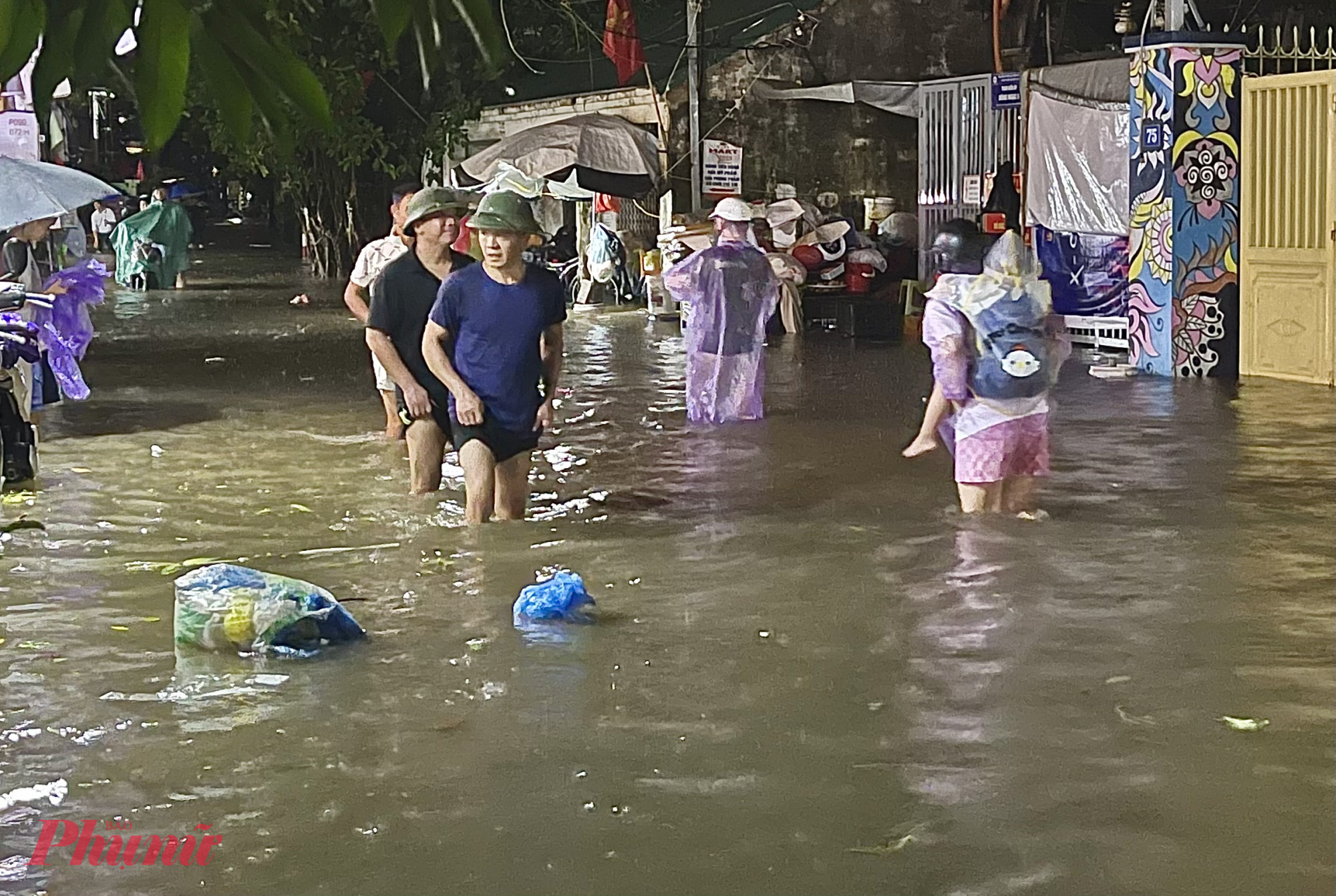 Mưa lớn, khu vực n&agrave;y chưa kịp tho&aacute;t nước, người d&acirc;n phải lội b&igrave; b&otilde;m đi lại.
