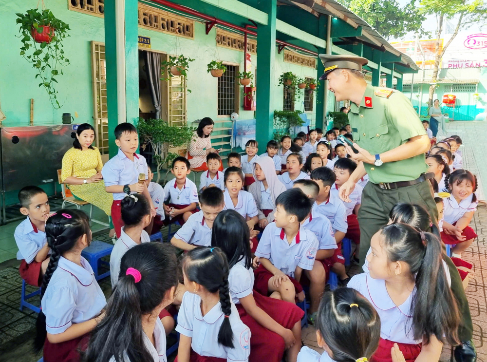 Lực lượng c&ocirc;ng an đến trường học ở TPHCM chia sẻ về những thủ đoạn lừa đảo online để học sinh cảnh gi&aacute;c - ẢNH: THANH B&Igrave;NH