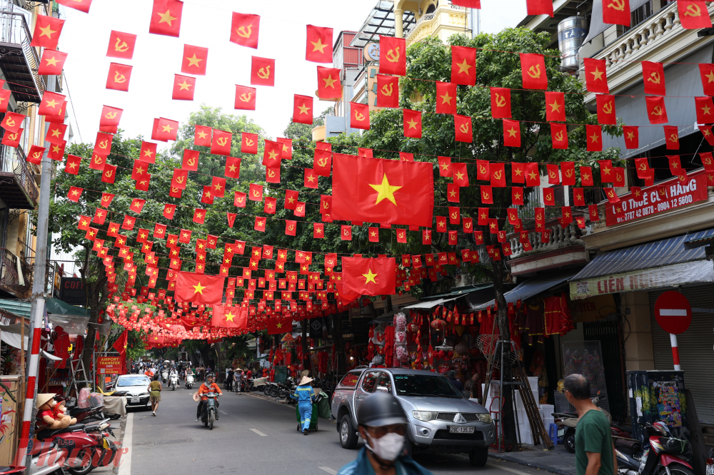 Những ng&agrave;y n&agrave;y, phố H&agrave;ng M&atilde; ngập sắc đỏ, cờ Tổ quốc tung bay rợp trời, phủ k&iacute;n cả chiều d&agrave;i con phố, tạo n&ecirc;n khung cảnh ấm &aacute;p, thi&ecirc;ng li&ecirc;ng mỗi dịp Quốc kh&aacute;nh.
