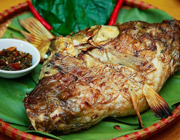 Pa pỉnh tộp l&agrave; m&oacute;n đặc sản nổi tiếng của người Th&aacute;i ở v&ugrave;ng T&acirc;y Bắc, được chế biến từ c&aacute; ch&eacute;p hoặc c&aacute; trắm tươi. C&aacute; sau khi l&agrave;m sạch được mổ dọc lưng, giữ nguy&ecirc;n th&acirc;n rồi ướp với mắc kh&eacute;n, rau thơm, gừng, tỏi, ớt v&agrave; nhiều gia vị đặc trưng của n&uacute;i rừng. Khi gia vị đ&atilde; ngấm, c&aacute; được kẹp tre v&agrave; nướng tr&ecirc;n bếp than hồng đến khi ch&iacute;n v&agrave;ng, dậy m&ugrave;i thơm quyến rũ. Pa pỉnh tộp ăn c&ugrave;ng cơm nếp v&agrave; rau sống, thịt c&aacute; ngọt, chắc, thấm đẫm hương vị, mang đậm bản sắc ẩm thực của người Th&aacute;i.