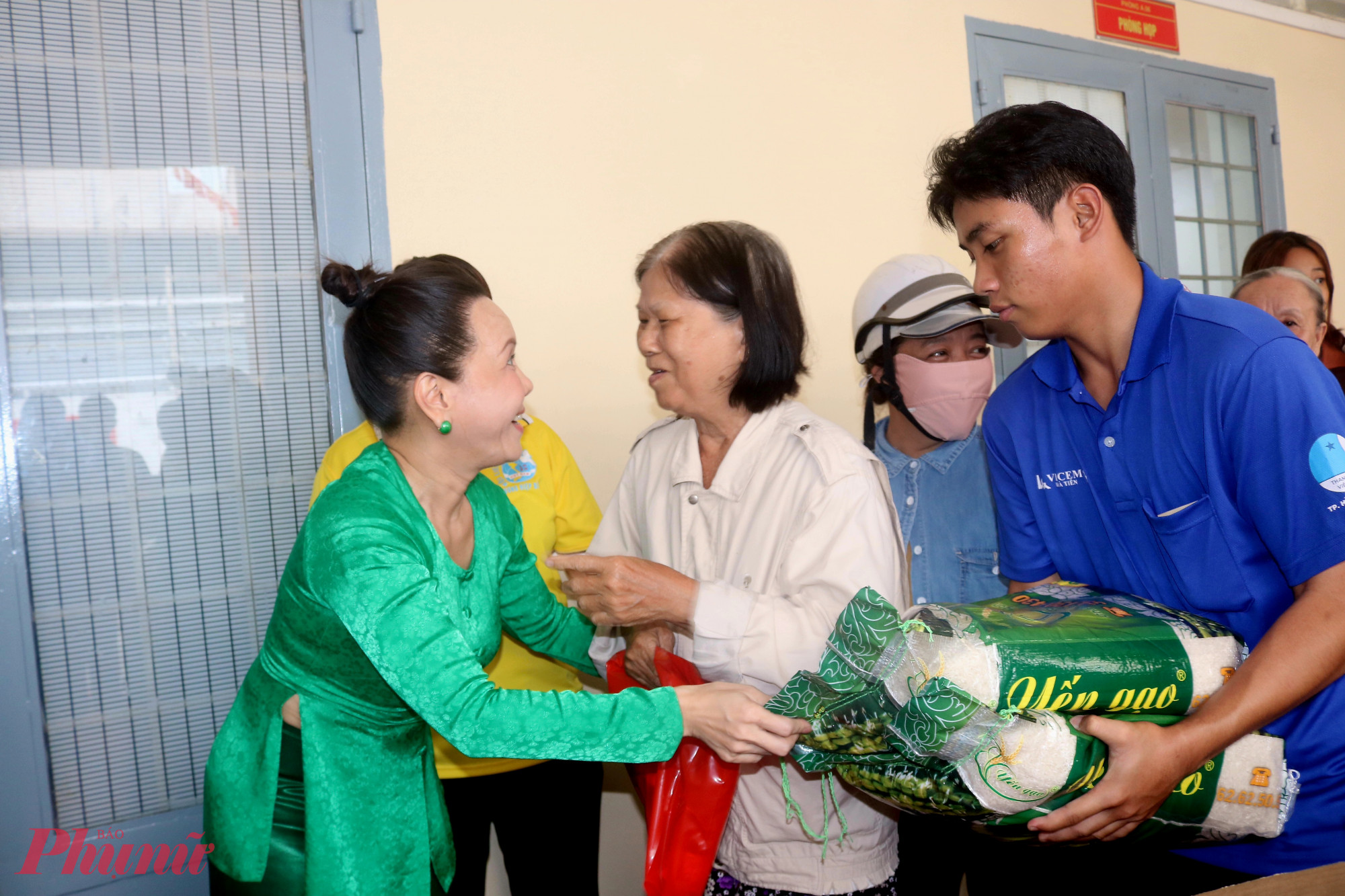 Nghệ sĩ Việt Hương (b&igrave;a tr&aacute;i) trao qu&agrave; v&agrave; động vi&ecirc;n đại diện c&aacute;c hộ d&acirc;n - Ảnh: Mẫn Nhi