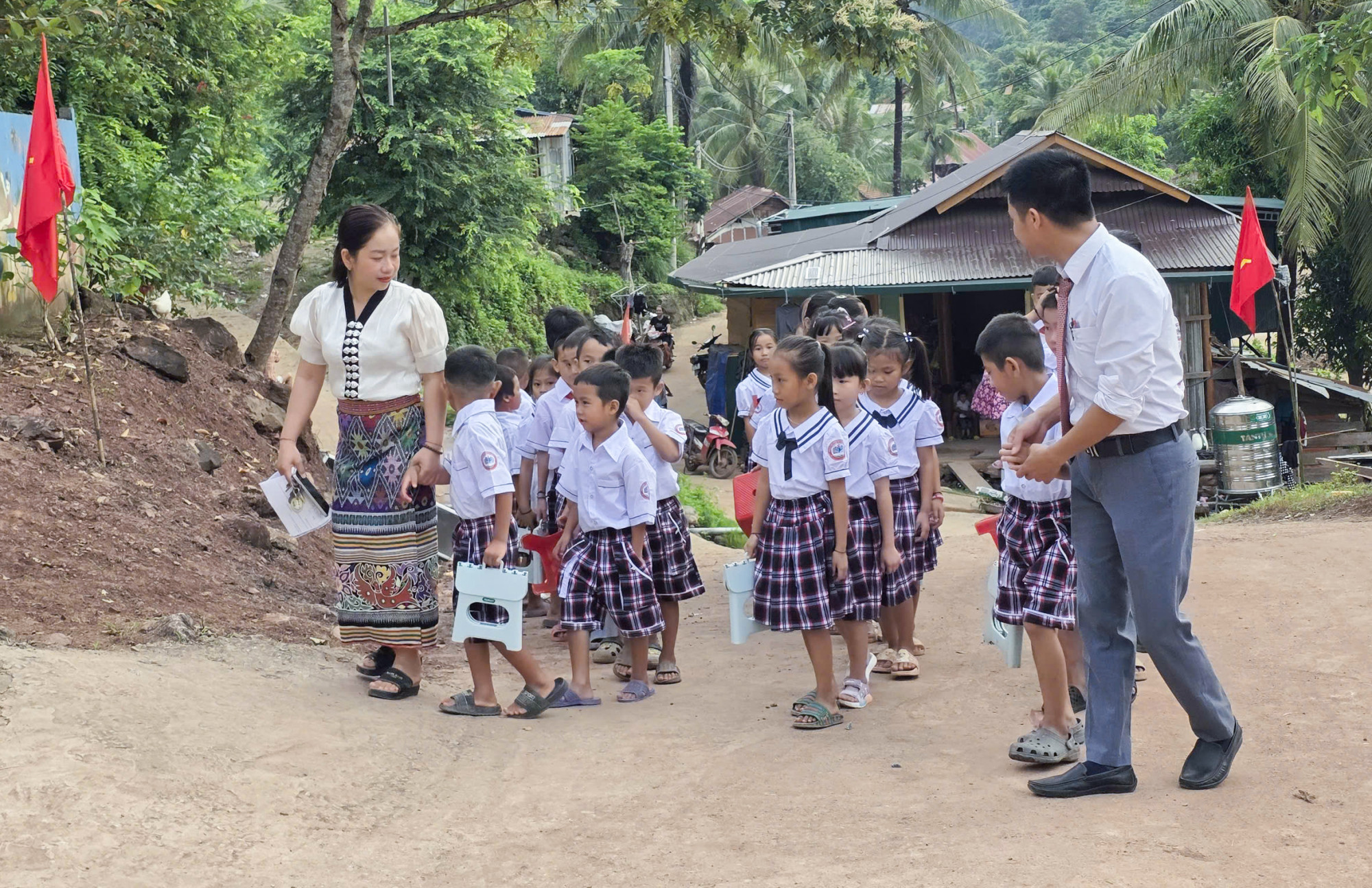 C&aacute;c em học sinh Trường Phổ th&ocirc;ng D&acirc;n tộc b&aacute;n tr&uacute; tiểu học Mỹ L&yacute; 2 phải đi khải giảng nhờ v&igrave; trường bị lũ t&agrave;n ph&aacute; - Ảnh: Kh&aacute;nh Trung