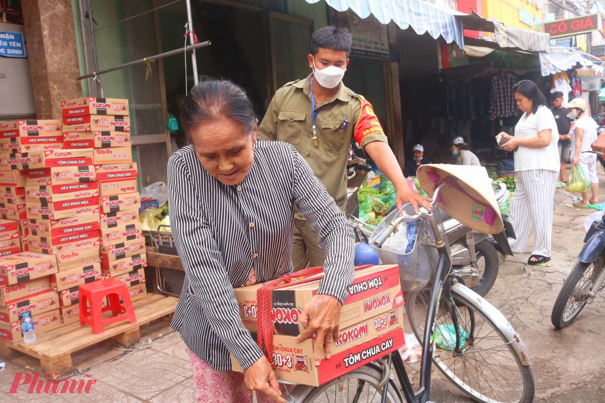 B&agrave; B&ugrave;i Thị Năm (70 tuổi), một phụ nữ b&aacute;n v&eacute; số ở phường Dĩ An, TPHCM nhận qu&agrave; từ chương tr&igrave;nh &ldquo;Triệu phần qu&agrave; san sẻ y&ecirc;u thương&rdquo; - Ảnh: Mẫn Nhi