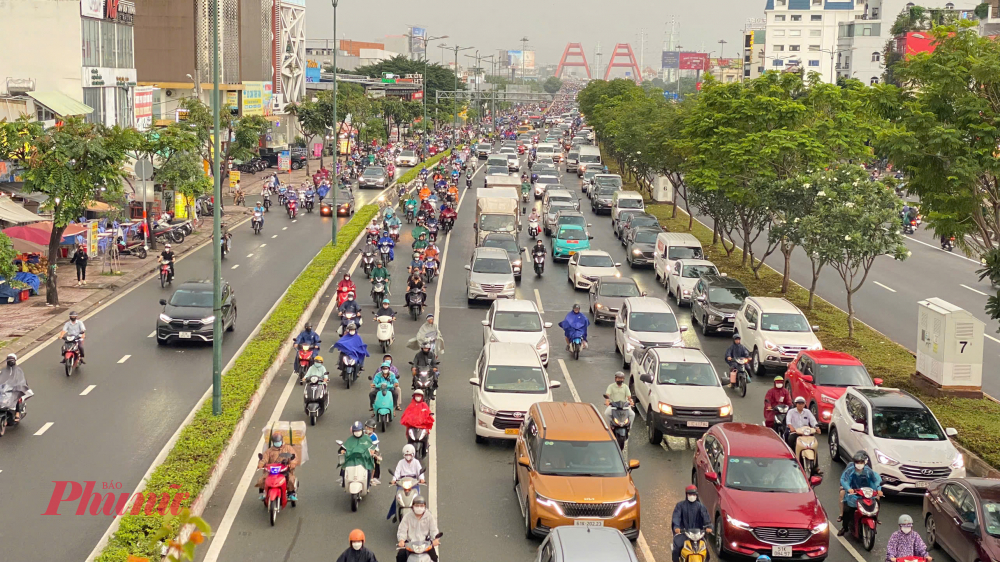 &Ocirc; t&ocirc; nối đu&ocirc;i nhau từ tr&ecirc;n cầu B&igrave;nh Lợi xuống đường Phạm Văn Đồng. 