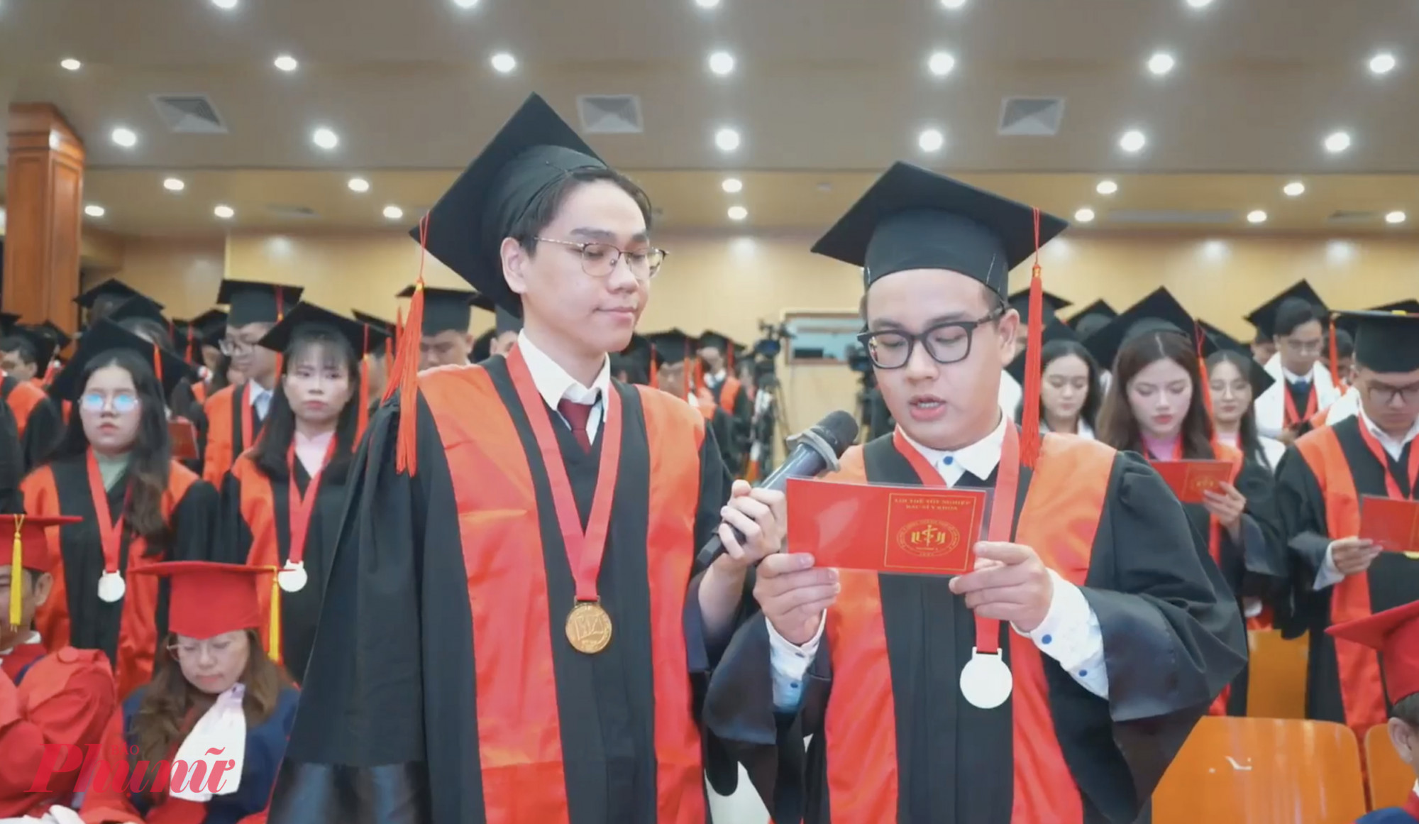 Thủ khoa đầu ra Dương Nhật Nam (b&ecirc;n tr&aacute;i) v&agrave; t&acirc;n b&aacute;c sĩ Phạm Duy T&acirc;n - Khối trưởng khối Y khađọc v&agrave; cam kết thực hiện lời thề y khoa - Ảnh: N.L