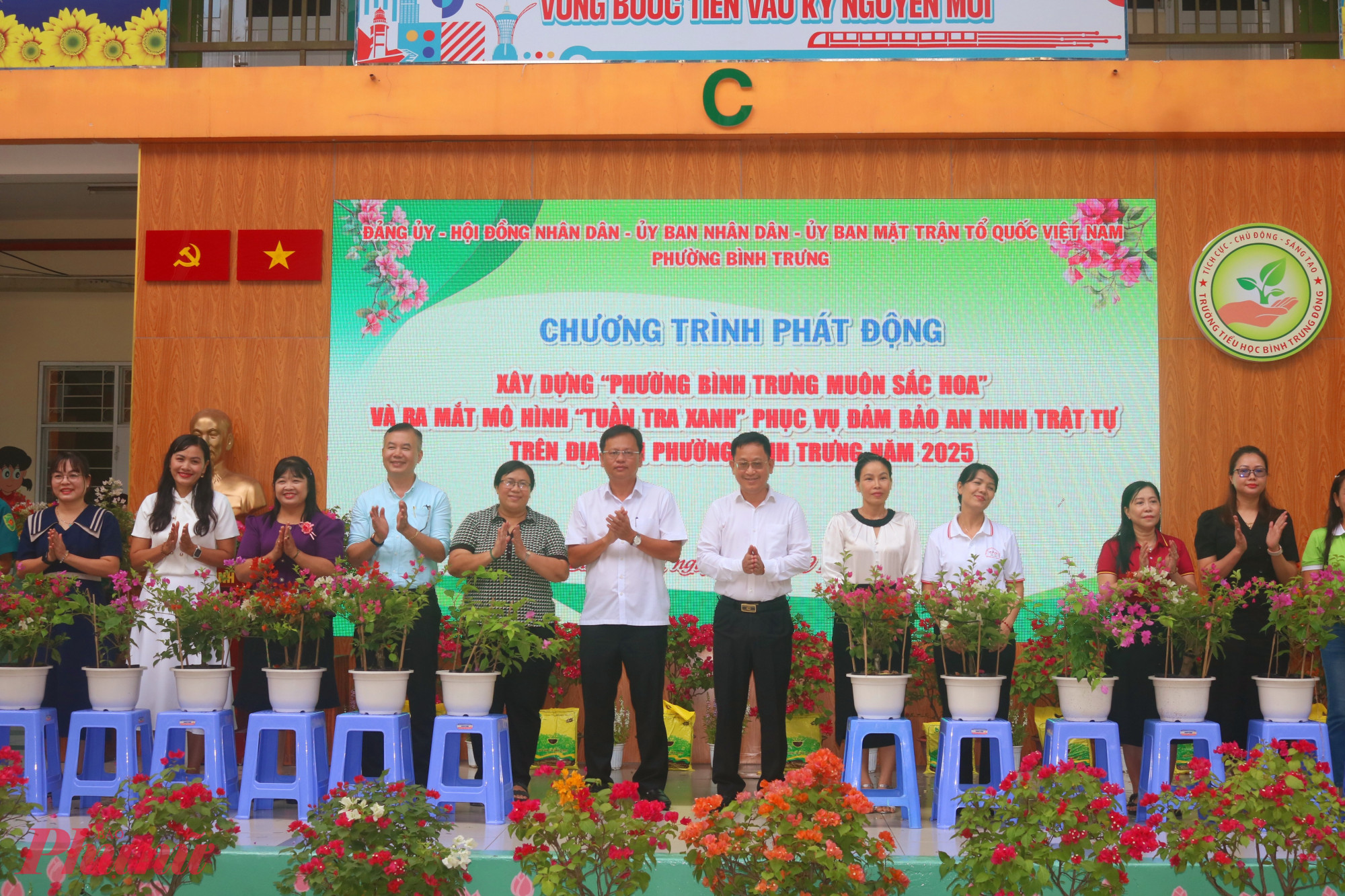 &Ocirc;ng Trần Quốc Trung &ndash; B&iacute; thư Đảng ủy, Chủ tịch HĐND phường B&igrave;nh Trưng (thứ 7, từ tr&aacute;i qua) v&agrave; &ocirc;ng L&ecirc; Quang Nam &ndash; Ph&oacute; b&iacute; thư thường trực Đảng ủy phường B&igrave;nh Trưng (thứ 6, từ tr&aacute;i qua) &ndash; trao chậu hoa giấy đến đại diện c&aacute;c khu phố - Ảnh: Mẫn Nhi