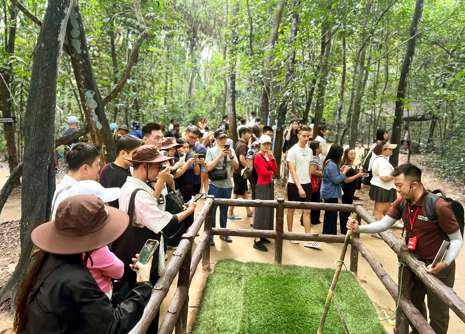 C&aacute;c hướng dẫn vi&ecirc;n của đơn vị lữ h&agrave;nh, dịch vụ du lịch tại TPHCM đang thuyết minh về địa đạo Củ Chi với kh&aacute;ch quốc tế