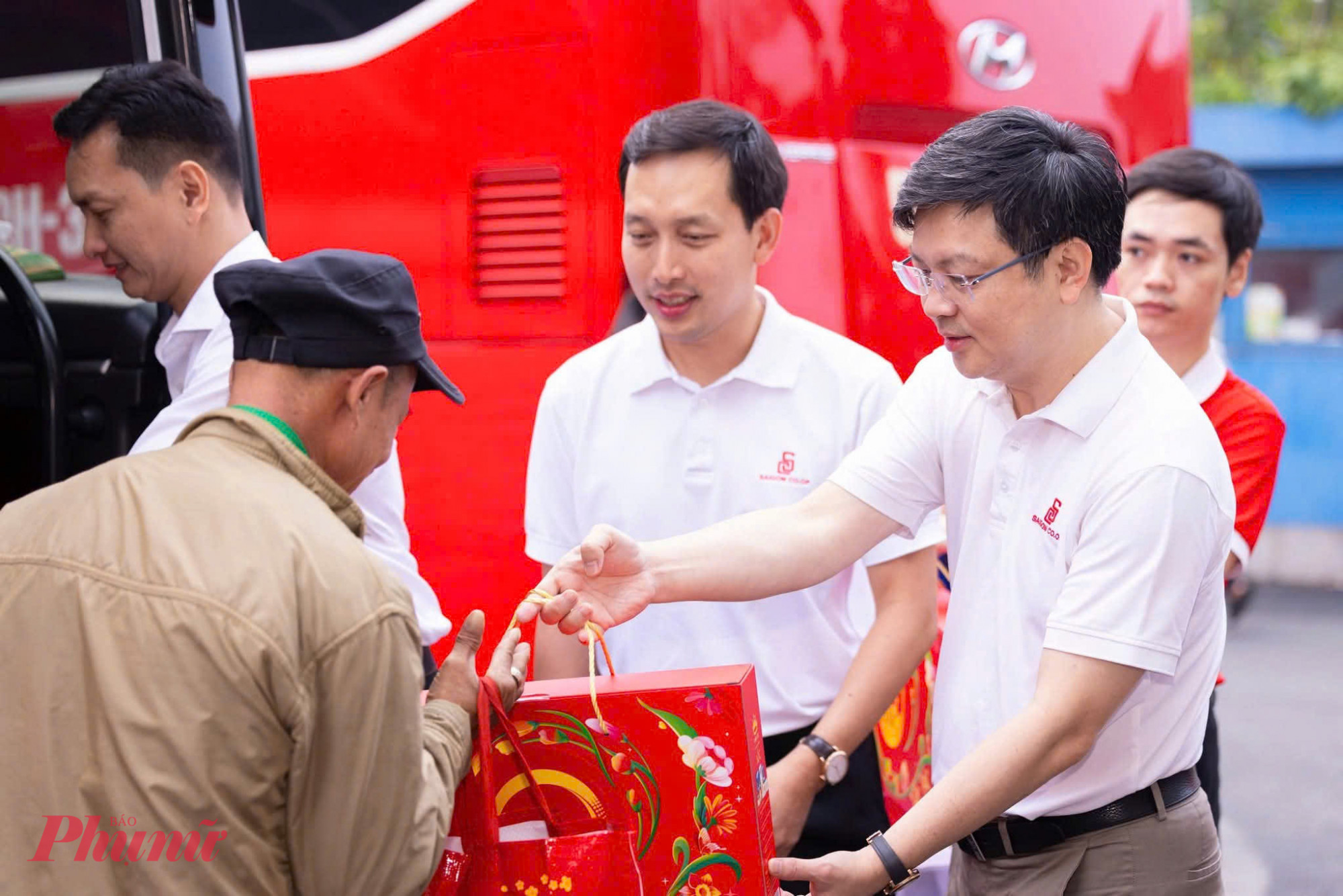 Đại diện ban tổ chức trao qu&agrave; tết, động vi&ecirc;n b&agrave; con trước khi bước l&ecirc;n xe về c&aacute;c tỉnh miền Trung v&agrave; T&acirc;y Nguy&ecirc;n.
