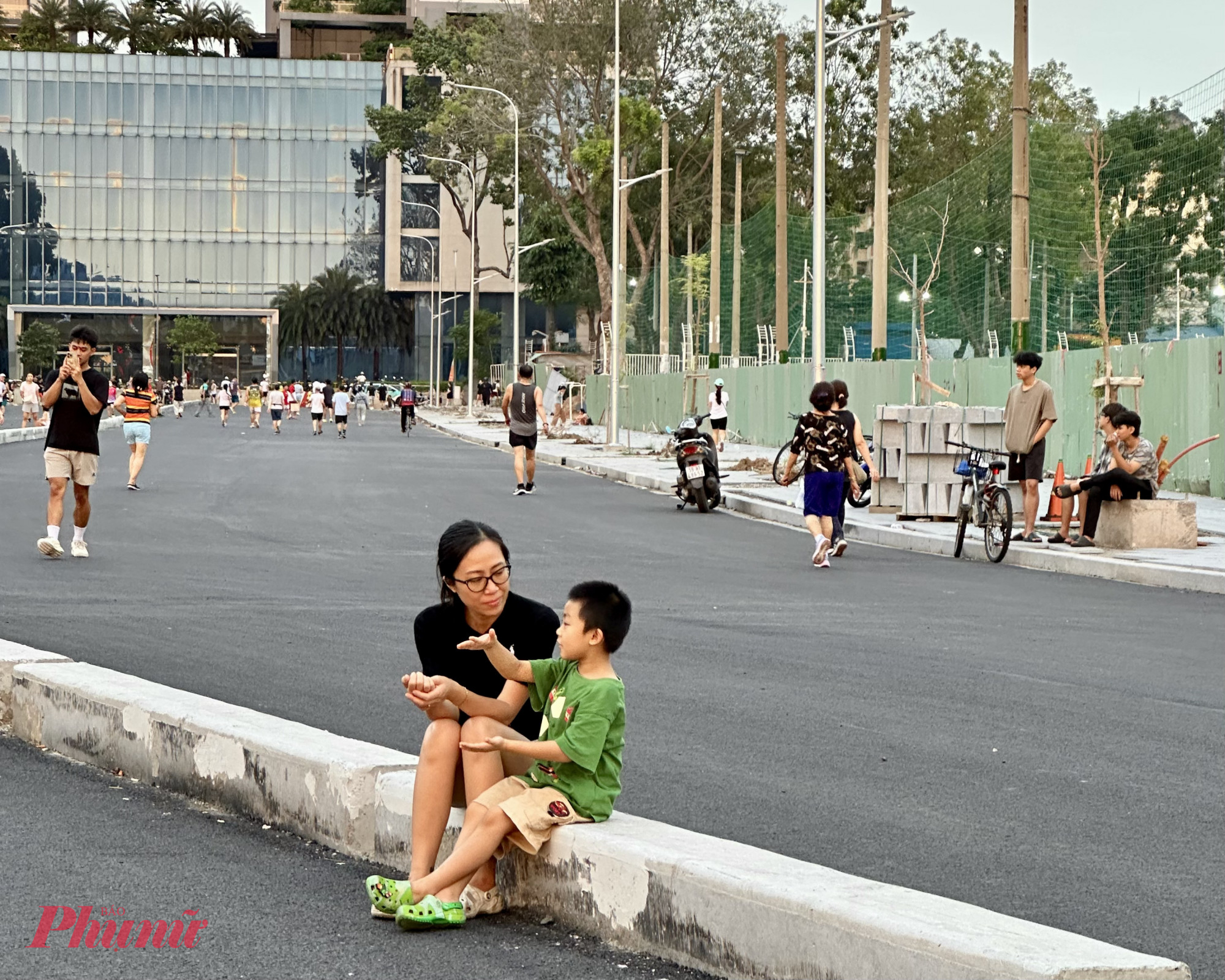 Hai mẹ con ngồi tr&ecirc;n d&atilde;i ph&acirc;n c&aacute;ch, chuyện tr&ograve; giản dị m&agrave; ấm &aacute;p &ndash; như thể nơi n&agrave;y vốn dĩ đ&atilde; l&agrave; một g&oacute;c quen của khu phố.