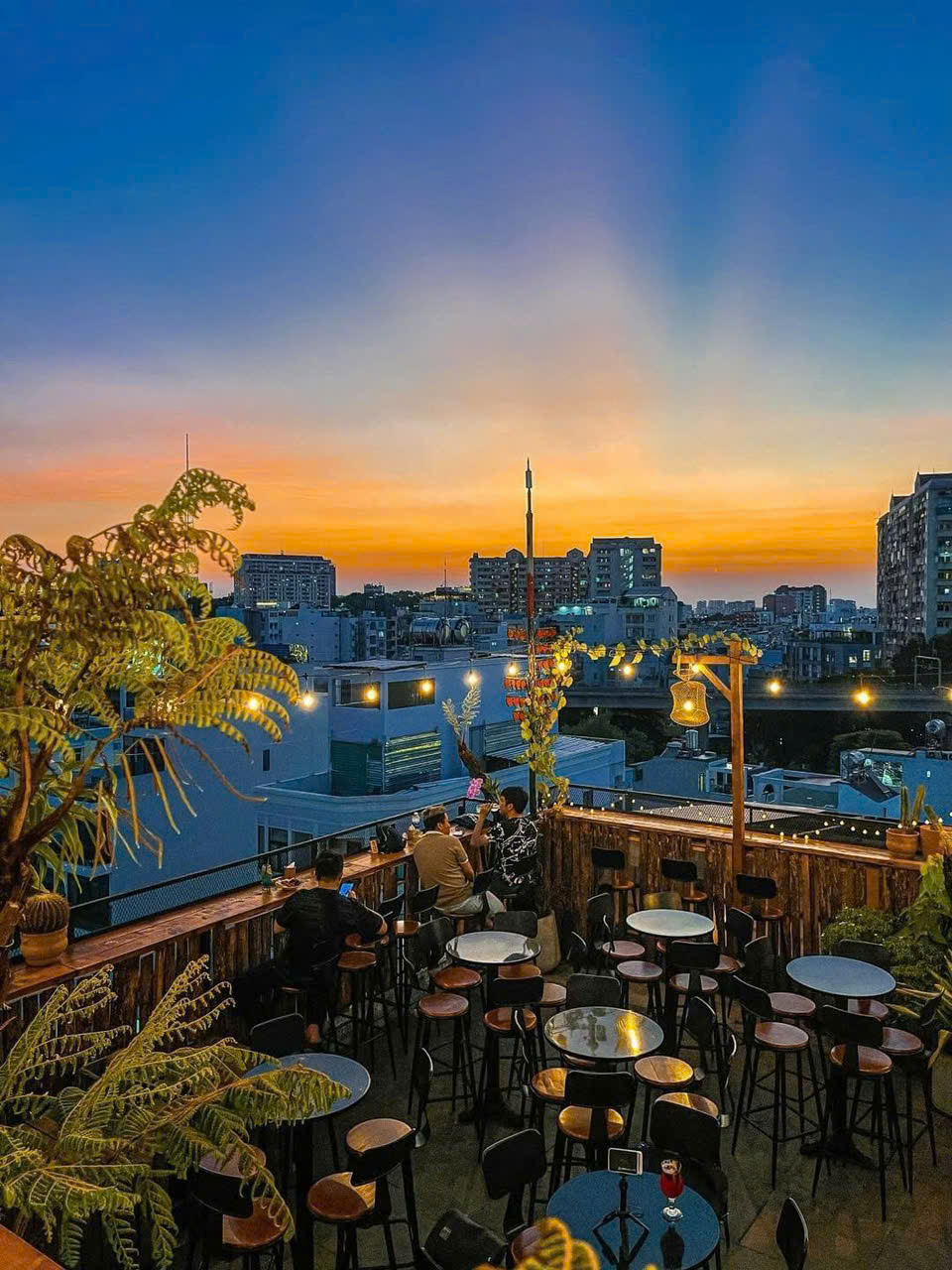 Kh&oacute;i Rooftop (1 Ph&uacute; Mỹ, phường Thạnh Mỹ T&acirc;y) l&agrave; địa điểm l&yacute; tưởng để bạn h&ograve;a m&igrave;nh v&agrave;o khoảnh khắc ho&agrave;ng h&ocirc;n bu&ocirc;ng xuống, trả lại S&agrave;i G&ograve;n sự b&igrave;nh y&ecirc;n sau một ng&agrave;y n&aacute;o nhiệt. Qu&aacute;n c&oacute; 2 tầng v&agrave; được trang tr&iacute; tỉ mỉ bằng những d&acirc;y đ&egrave;n, chậu c&acirc;y nhỏ xinh tạo ra một kh&ocirc;ng gian mở, tho&aacute;ng m&aacute;t nhưng kh&ocirc;ng k&eacute;m phần ấm &aacute;p - Ảnh: @Trăng Non Rooftop