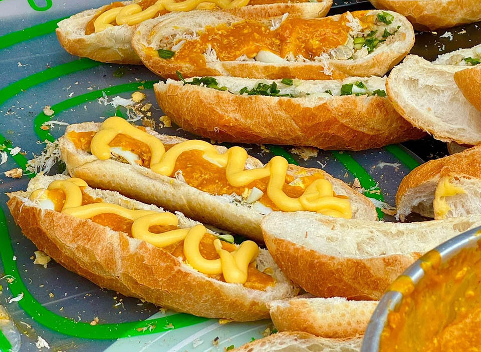 Giữa v&ocirc; v&agrave;n biến tấu của b&aacute;nh m&igrave; Việt, b&aacute;nh m&igrave; sốt gạch cua nổi bật hơn cả nhờ hương vị đậm đ&agrave;. Điều l&agrave;m n&ecirc;n danh tiếng của b&aacute;nh m&igrave; gạch cua ch&iacute;nh l&agrave; phần sốt v&agrave;ng &oacute;ng, s&aacute;nh mịn v&agrave; thơm ngậy m&ugrave;i gạch cua biển. Lớp sốt n&agrave;y kh&ocirc;ng chỉ b&eacute;o ngậy m&agrave; c&ograve;n đậm đ&agrave; vị umami tự nhi&ecirc;n từ hải sản tươi sống. Khi cắn v&agrave;o, thực kh&aacute;ch sẽ cảm nhận được sự h&ograve;a quyện tuyệt vời giữa sốt gạch cua, thịt băm được n&ecirc;m nếm vừa vặn, mỡ h&agrave;nh thơm lừng, thịt cua biển ngọt chắc v&agrave; trứng c&uacute;t b&eacute;o b&ugrave;i. Tất cả những nguy&ecirc;n liệu n&agrave;y được nướng sơ tr&ecirc;n mai cua trước khi được cho v&agrave;o ổ b&aacute;nh m&igrave;.