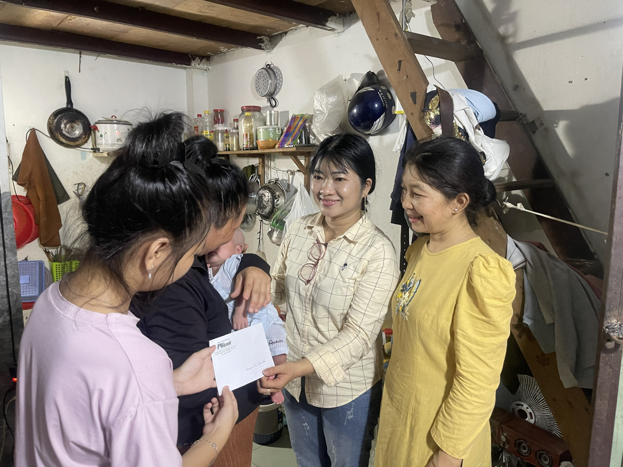 Chị Nguyễn Thị Thanh Th&uacute;y (b&igrave;a phải) c&ugrave;ng đại diện B&aacute;o Phụ nữ TPHCM đến thăm v&agrave; số tiền bạn đọc gi&uacute;p đỡ b&eacute; D.B.N. - &Atilde;nh: Trần Tr&uacute;c