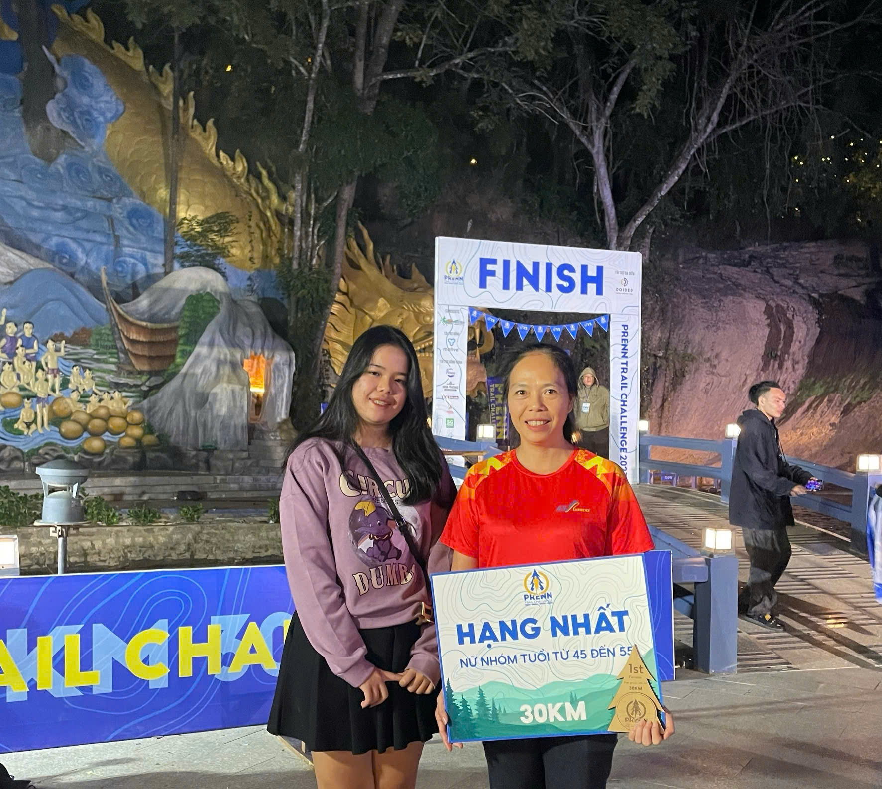 Con g&aacute;i chị Thuận đi theo mẹ đến đường chạy để cổ vũ