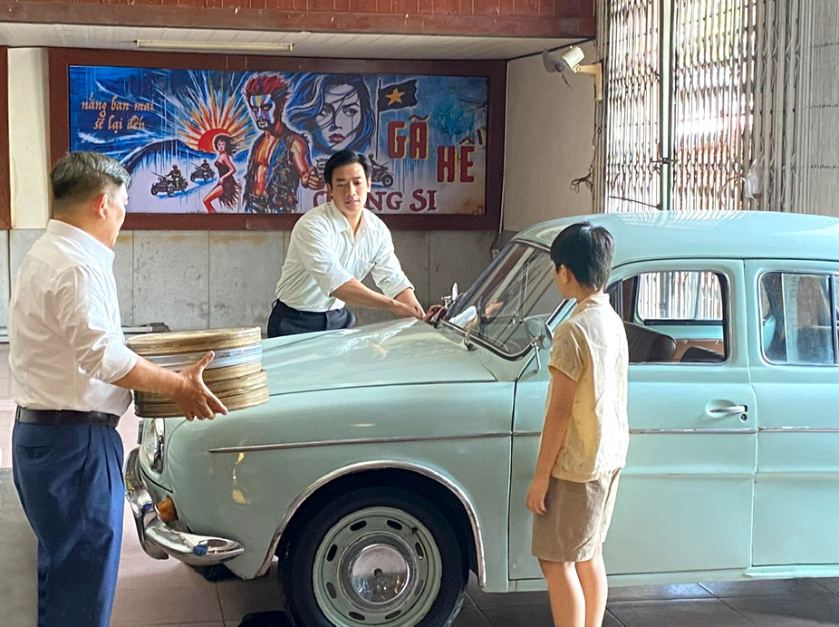 M&ocirc;̣t cảnh trong phim Chớp b&oacute;ng xuất hiện 2 đạo cụ xưa l&agrave; hộp phim v&agrave; chiếc xe cổ - ẢNH: HMH