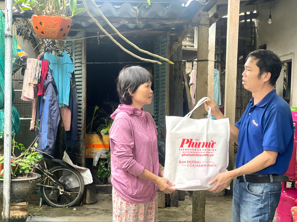 Ph&oacute;ng vi&ecirc;n Thuận H&oacute;a (B&aacute;o Phụ nữ TPHCM) trao qu&agrave; của bạn đọc hỗ trợ b&agrave; L&ecirc; Thị C&uacute;c (ngụ x&atilde; Quảng Điền, TP Huế) - ẢNH: NGỌC MINH