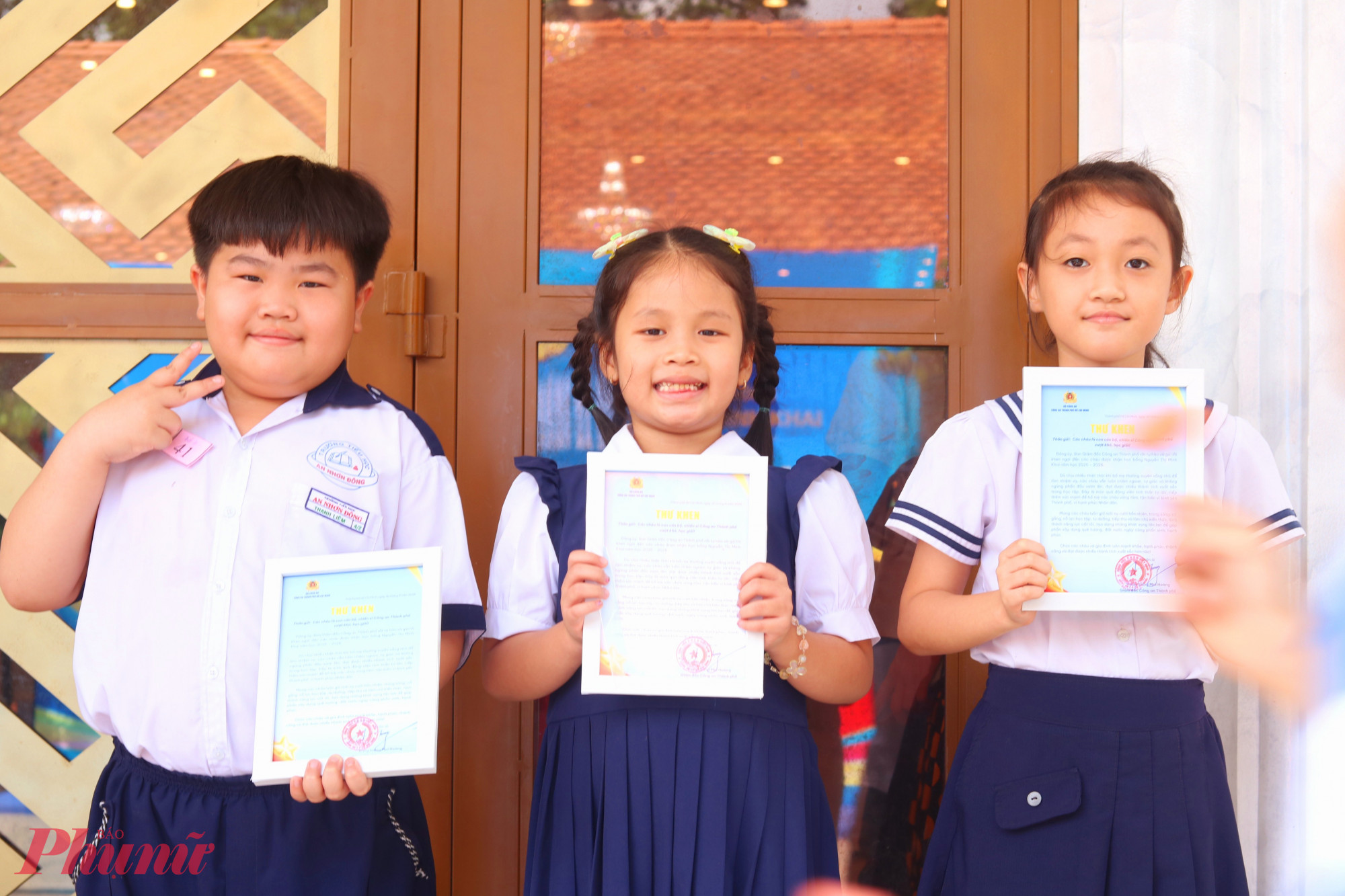 C&aacute;c em học sinh phấn khởi khoe thư khen của Ban Gi&aacute;m đốc C&ocirc;ng an TPHCM - Ảnh: Mẫn Nhi