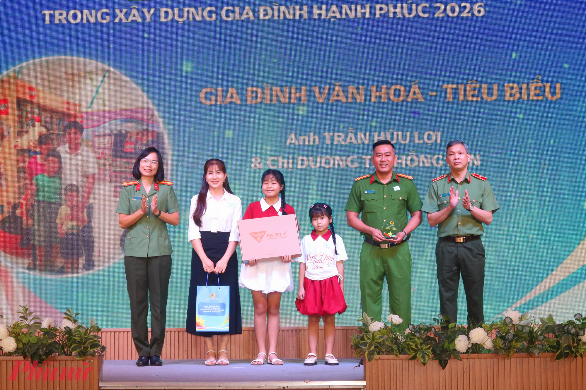 Thiếu tướng Tạ Văn Đẹp (b&igrave;a phải) v&agrave; thượng t&aacute; Nguyễn Thị Quế (b&igrave;a tr&aacute;i) trao qu&agrave; đến c&aacute;c gia đ&igrave;nh được tuy&ecirc;n dương - Ảnh: Mẫn Nhi