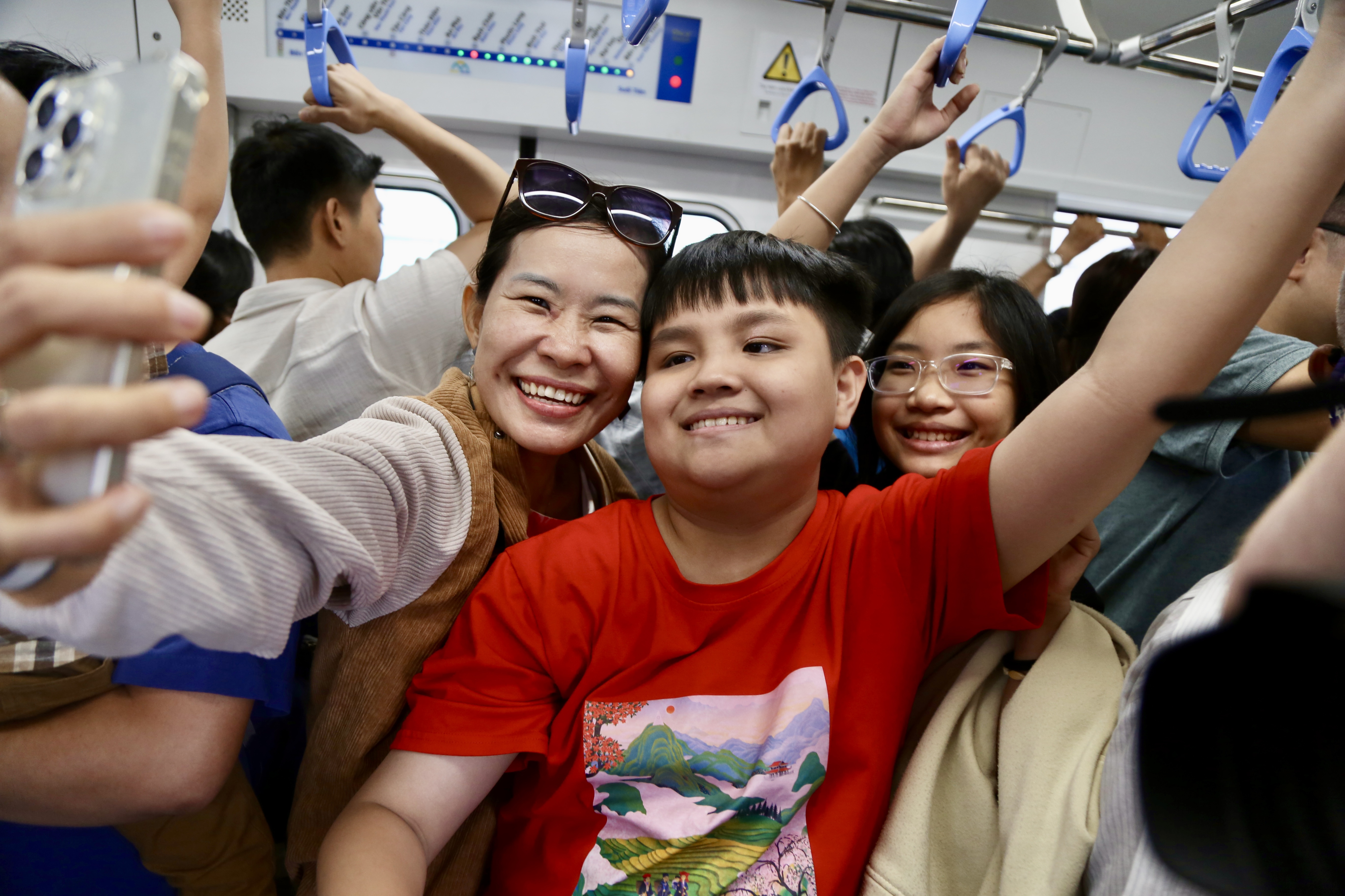 Trong ngày vận hành chính thức, dù rất đông người đi metro nhưng ai nấy cũng đều vui vẻ, phấn khởi. Ảnh: HOÀNG GIANG