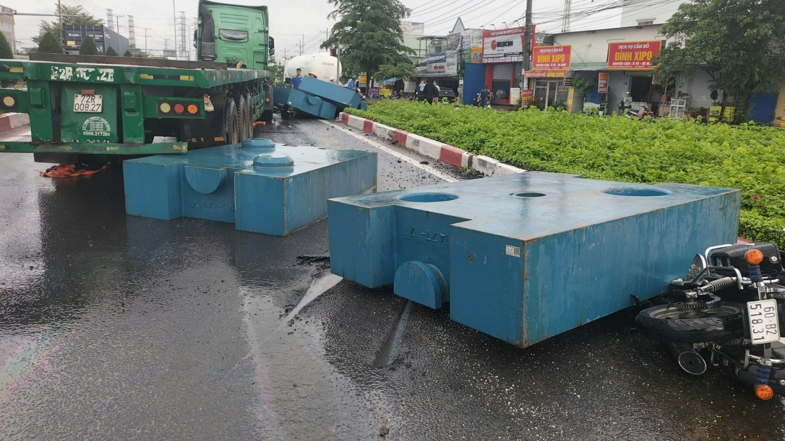 Một người đi xe mô tô bị thương khi cục sắt to trên xe container 'bay' xuống đường