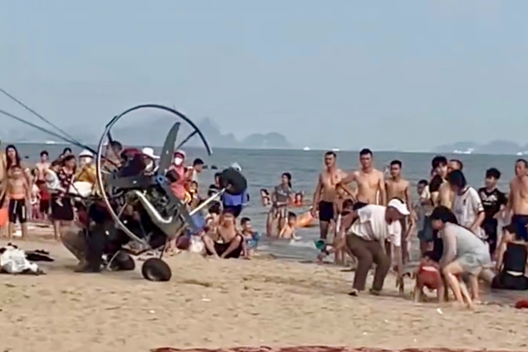 dù lượn gắn động cơ va phải du khách trên bãi biển Bãi Cháy khi đang cất cánh, không bảo đảm an toàn. Ảnh cắt từ clip
