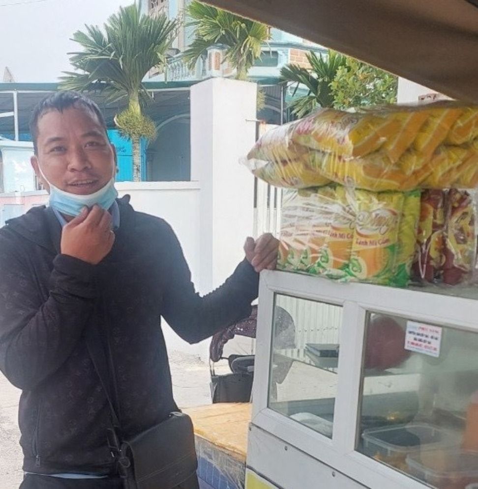 Anh Lê Trọng Huy bên cạnh cửa hàng bánh mì anh mới mở nhờ trúng giải thưởng triệu phú khi giải khát với Trà Xanh Không Độ trong hè 2023.jpg