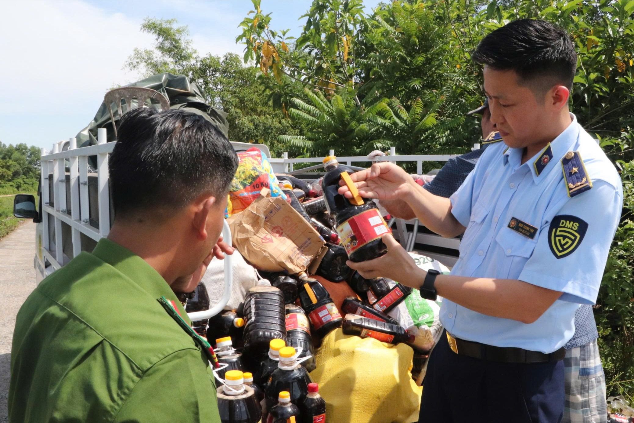 Lực lượng côn an, quản lý thị trường thu gom số nước mắm vứt bỏ bên đường.