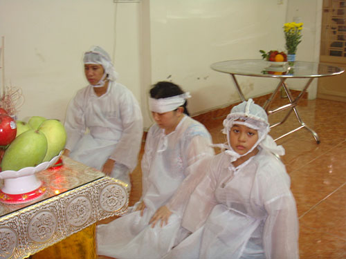 Bà Dương Thị Thảo cùng 2 con thắp hương chuẩn bị cúng cơm cho chồng, cha là ông Nguyễn Văn Chín và bút tích của ông Chín (ảnh nhỏ)